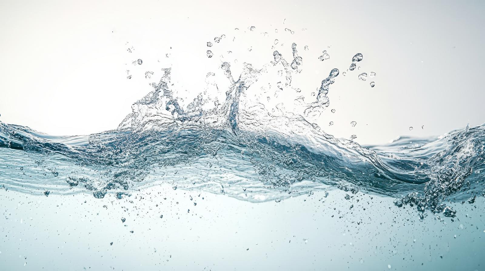 水が波打ち水面を突き破り、水飛沫と気泡が散る瞬間