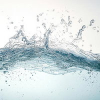 水が波打ち水面を突き破る瞬間の水飛沫と気泡の写真