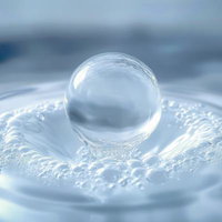 水滴が水面にあたって波紋ができる瞬間、光が反射して輝くの写真