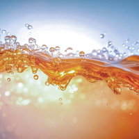 黄金色に染まる液体が跳ねるしぶきと波紋、光が反射する水滴の写真