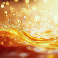 黄金色に輝く有効成分エキス配合の水沫と光の粒子の写真