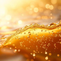 黄金色に輝くビールの泡立ちと煌めき、琥珀色の液体の写真