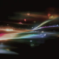 暗闇に浮かぶ虹色の光の軌跡が交差する夜景の写真