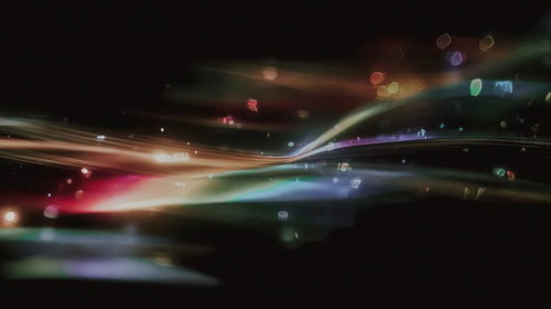 暗闇に浮かぶ虹色の光の軌跡が交差する夜景