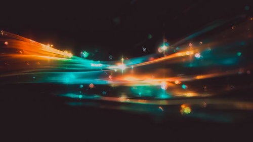 暗闇に伸びる鮮やかな光の帯が交差する風景