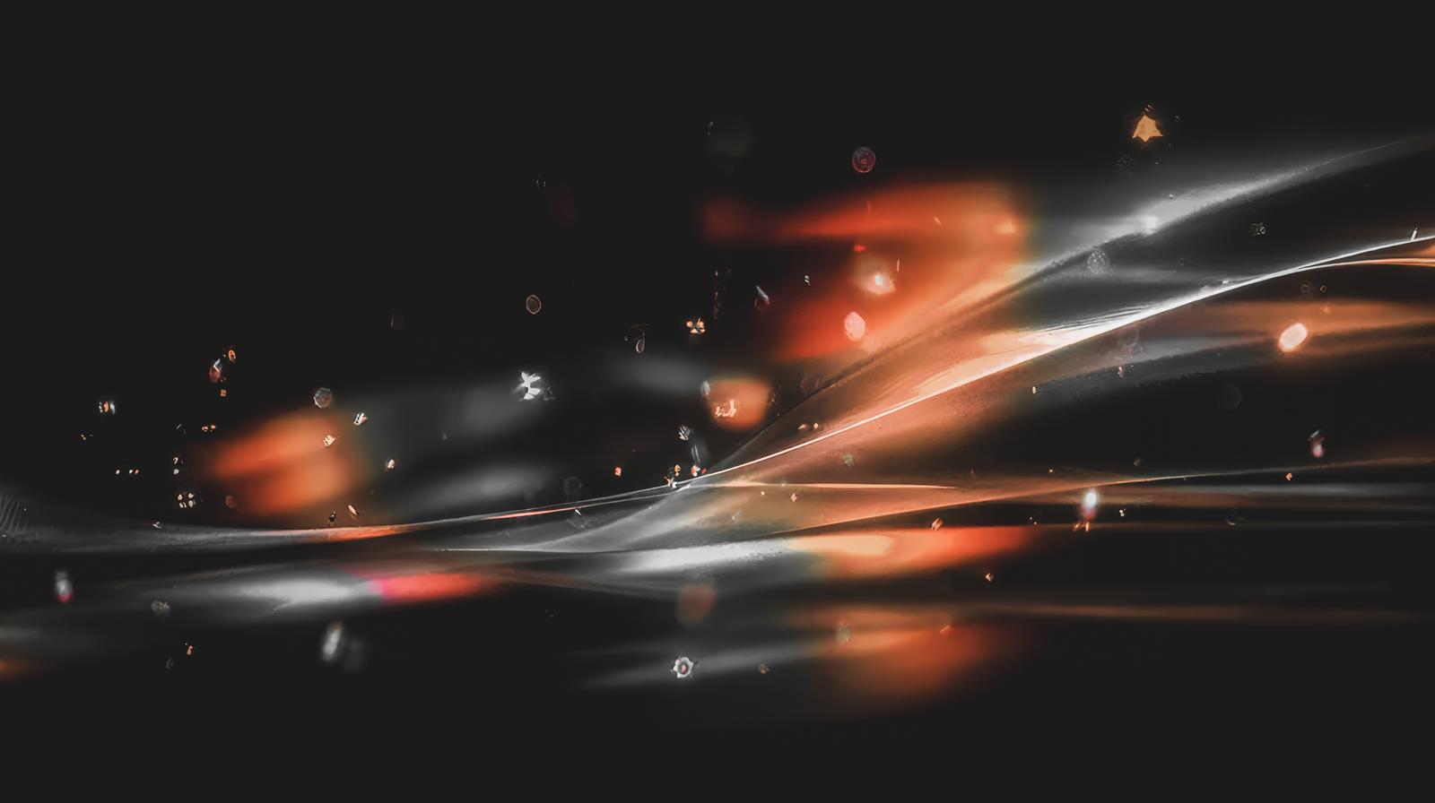 オレンジと白の光線が交差し流れる近未来的な光の軌跡