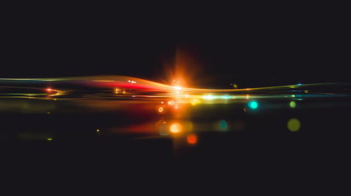 暗闇の中で交差するエネルギーの光線と軌跡