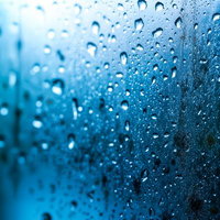 窓ガラスを伝う雨粒の写真