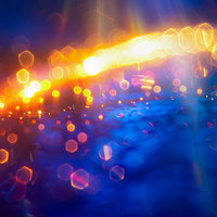 青とオレンジが交差する光の軌跡デザイン・ボケと輝きのライトトレイルの写真
