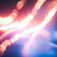 光が描く優雅なラインと煌めく輝き、ピンク色と青白いネオングローの写真