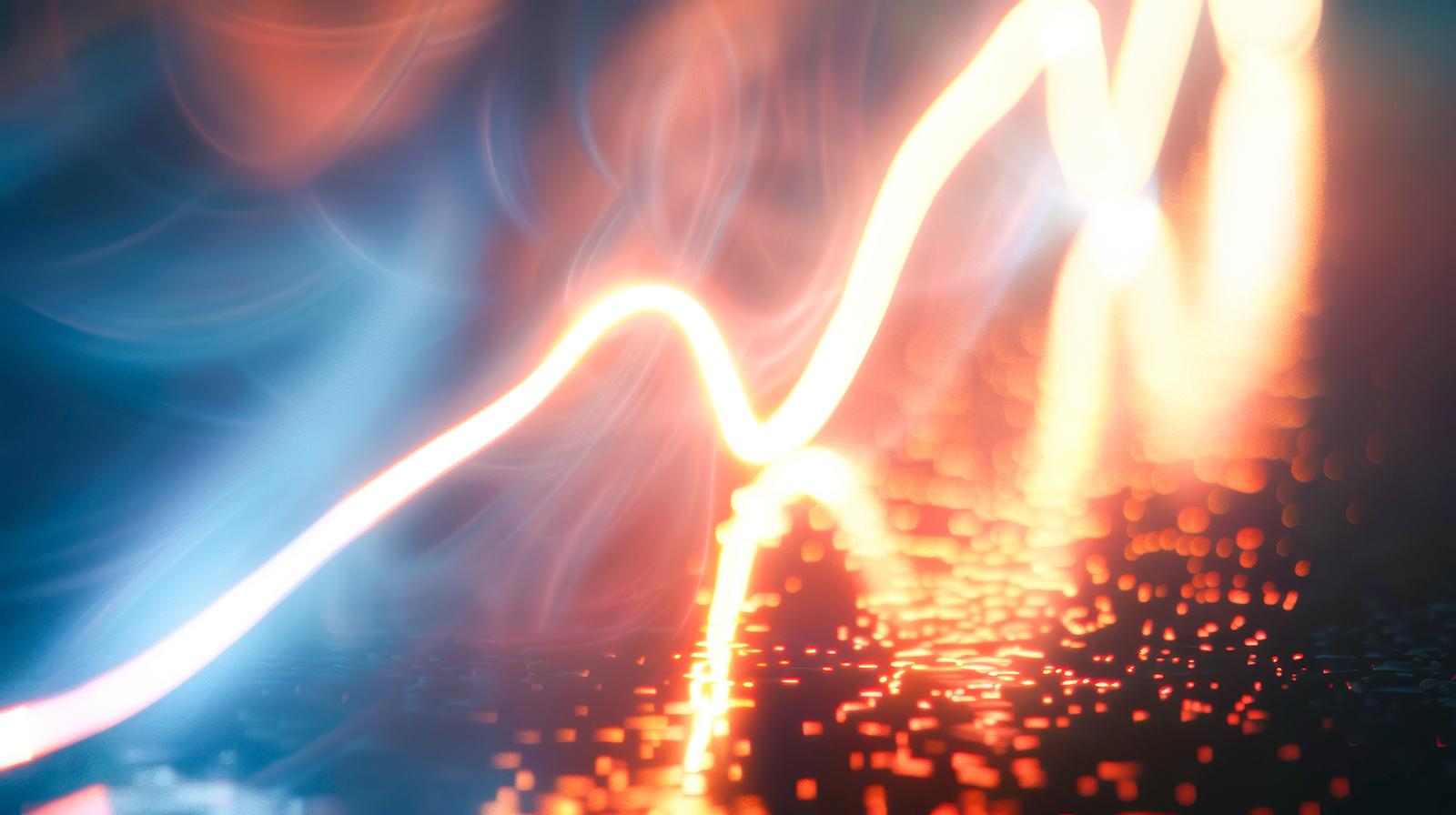 オレンジ色と白い光が交差し、火花のように散る光の粒子