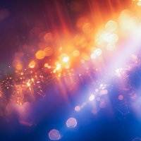 レンズフレアが差し込む光の粒子 オレンジから青紫へのグラデーションの写真