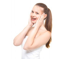 両手を頬に当てながら驚いた表情をする女性の写真