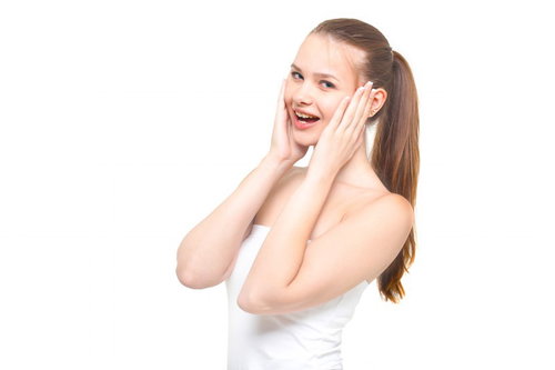 両手を頬に当てながら驚いた表情をする女性