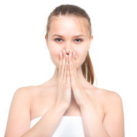両手を口元で合わせて驚く女性、白背景でのビューティ表現の写真