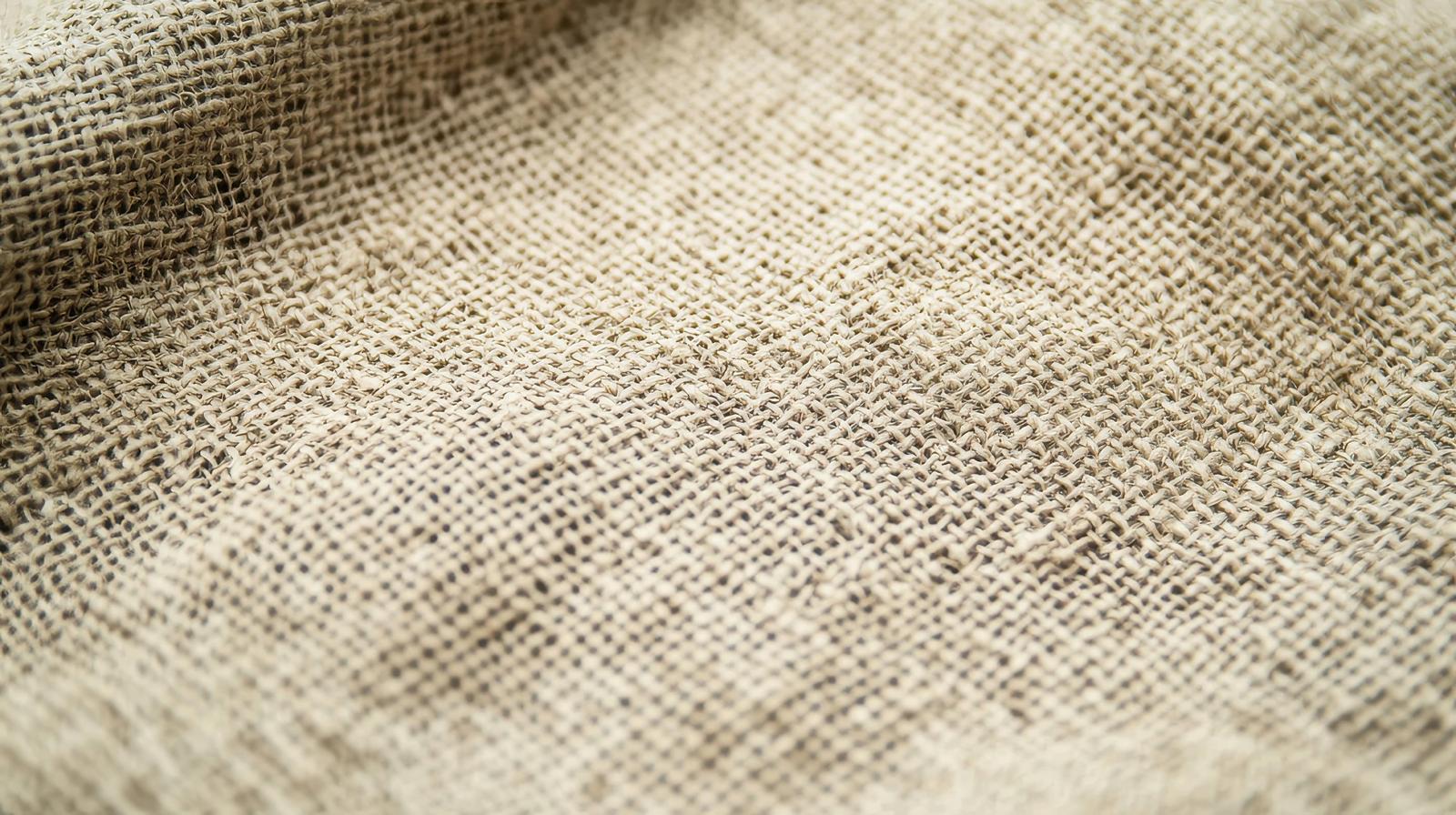 Closeup of beige-colored coarse linen fabric texture