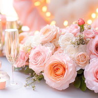 ピンク色の薔薇の花とシャンパングラスのテーブルセッティングの写真