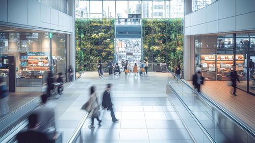 往来する人々と緑で彩られた商業施設の空間