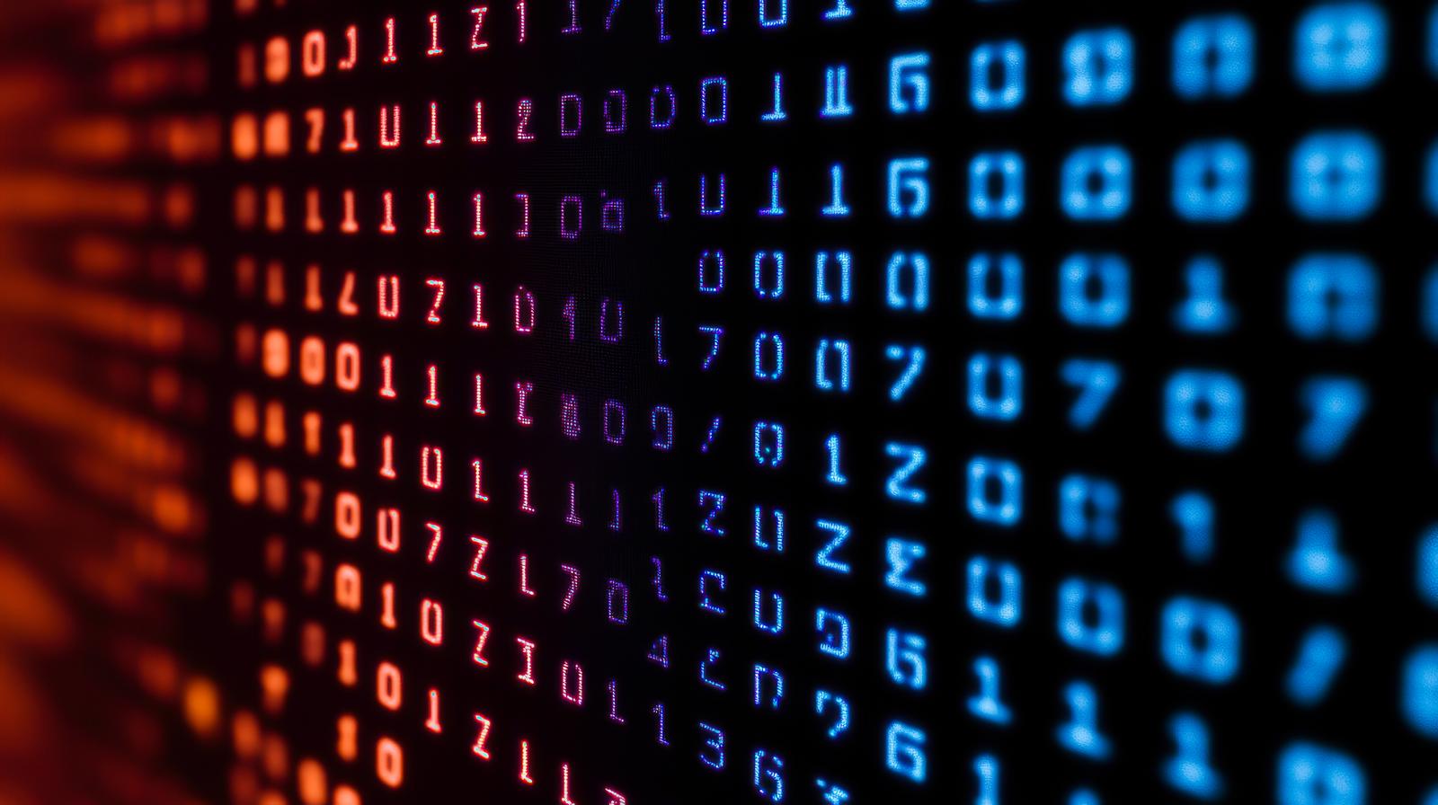 赤いバイナリーコードが表示されたモニターと青ピンク色のボケた光