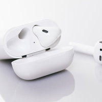 白いケースにいれて充電中のワイヤレスイヤホンの写真