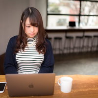 カフェでノーパソを操作するむちむち美女のリモートワーク風景の写真