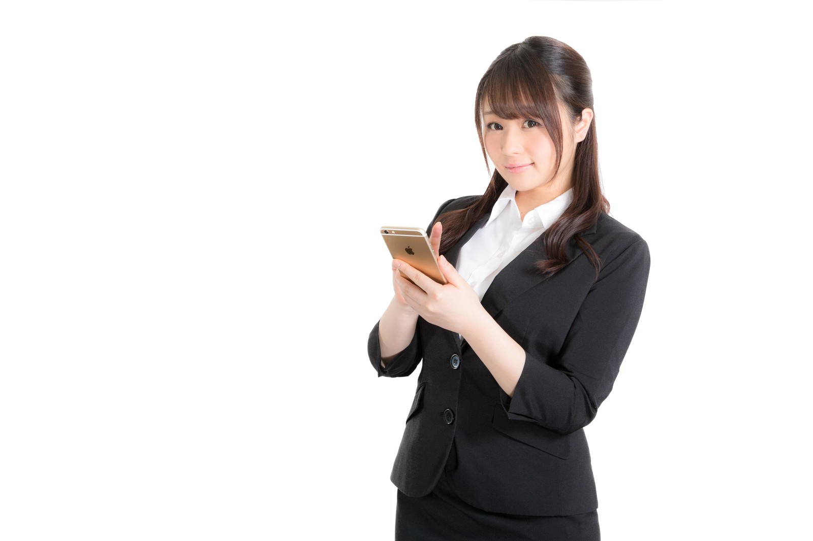 黒いスーツの女性がスマホで予定を確認しながら笑顔で上を向いている［モデル：茜さや］