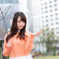 雨の降る都市で傘を持つお天気キャスター、天気予報の写真