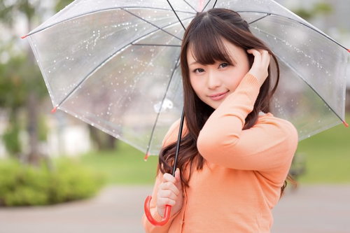 雨の中で髪をかきあげる、ジメジメ湿気でもキレイをキープする女性