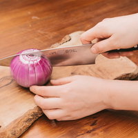 木製まな板で赤玉ねぎを16等分にカット中の写真