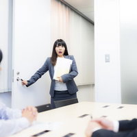 会議室を間違えて目を丸くする女性ビジネスパーソンの写真