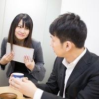 「お茶どうぞ」と意味深な笑顔で打ち合わせに茶々を入れる小悪魔女子の写真