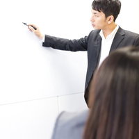 社運をかけたプレゼンにペンを持つ手が震えるビジネスパーソンの写真