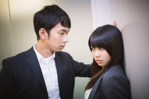 オフィスで壁ドンをする上司とドン引きする部下