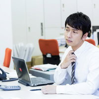 残業開始時にネクタイを緩める社畜の写真