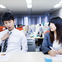 残業中ぐちぐち愚痴を言い合う社内カップルの写真