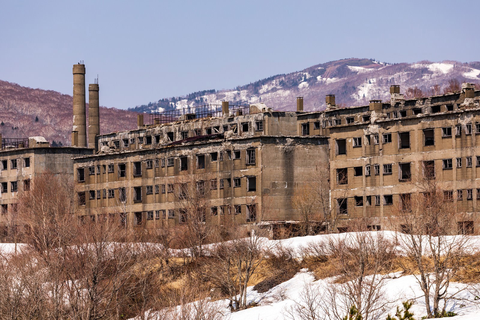 雪景色の中に建ち並ぶ松尾鉱山の廃宿舎群