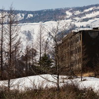 残雪に覆われた松尾鉱山の宿舎跡アパート建物の写真