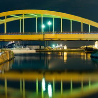小樽運河の夜景、ライトアップされた黄色い橋と倉庫群の写真