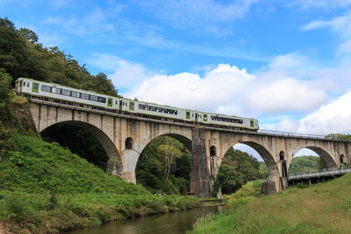 釜石線が走る岩手県のめがね橋、石造りのアーチ橋を電車が渡る