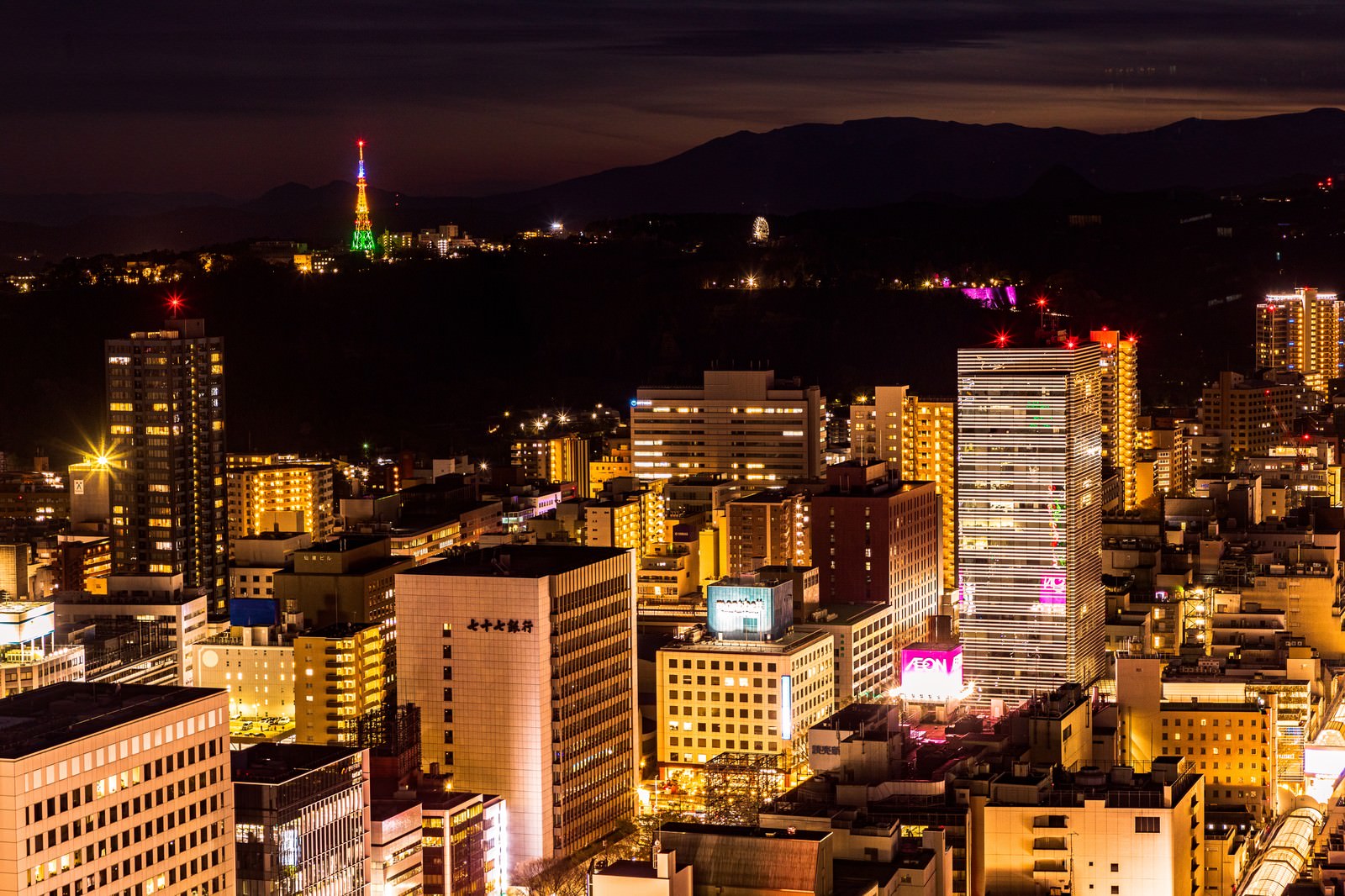 オレンジ色の照明に照らされた仙台の高層ビル群の夜景