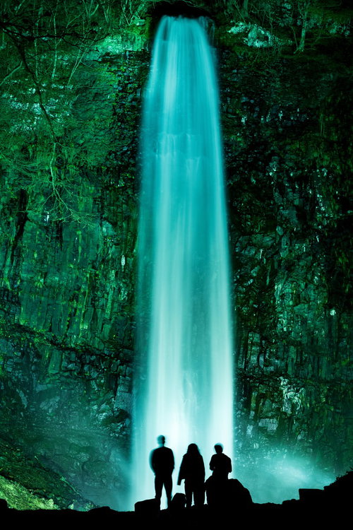 ライトアップされた玉簾の滝を眺めるシルエットの観光客