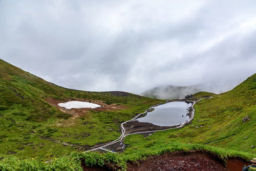 秋田駒ヶ岳の阿弥陀池と眼下に迫る雲の風景