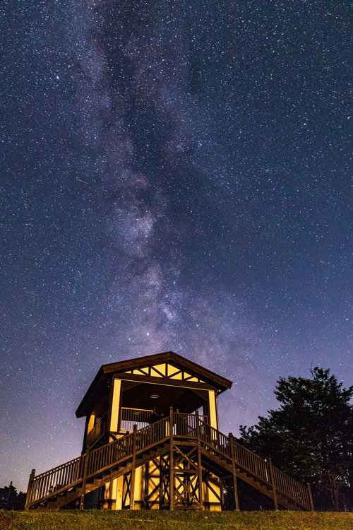 ラベンダー園の小屋と夜空に流れる天の川の星空風景