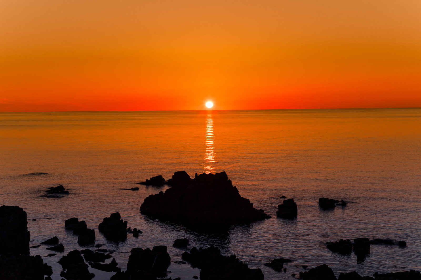 入道崎から見た日本海の夕日とレイライン、オレンジ色の夕焼け