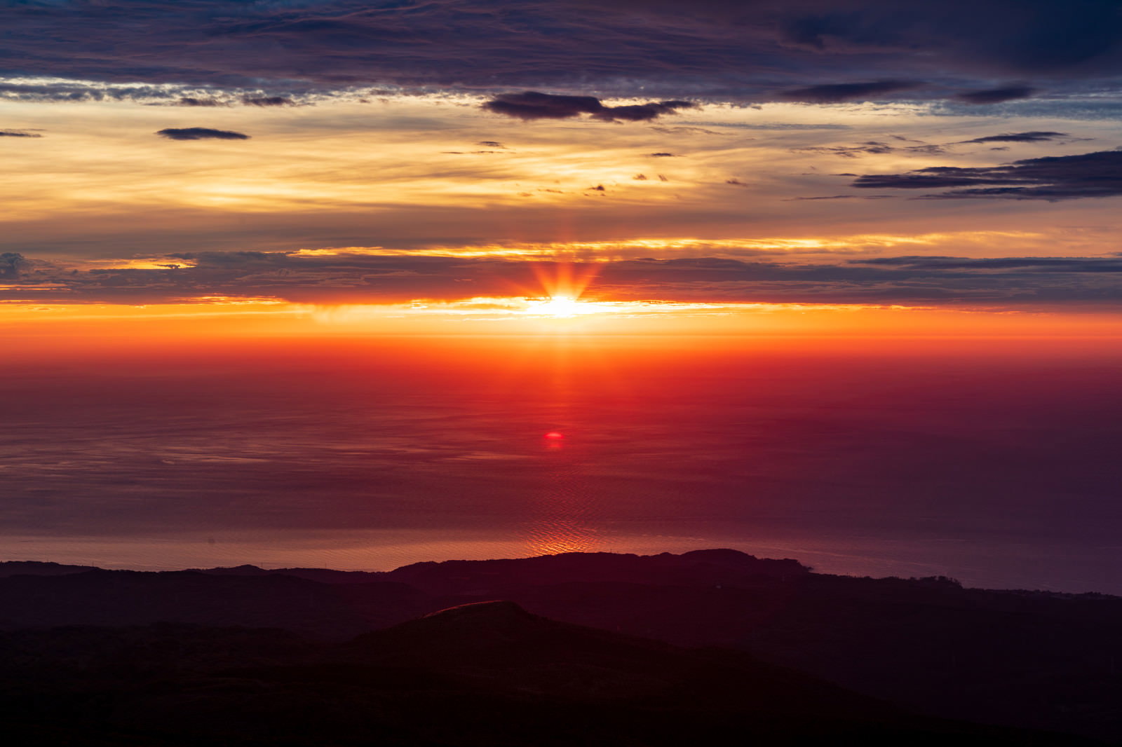 海の水平線に沈む夕日と夕焼け空