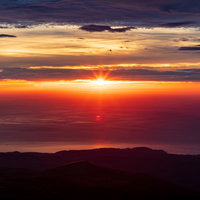 海の水平線に沈む夕日と夕焼け空の写真