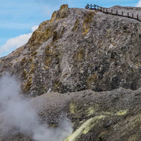 噴き出す火山ガスと川原毛地獄の荒涼とした岩肌の写真