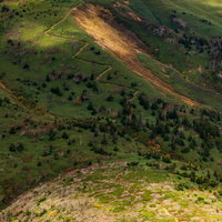 雲の陰に覆われる八幡平の急登な登山道を歩く登山者の写真