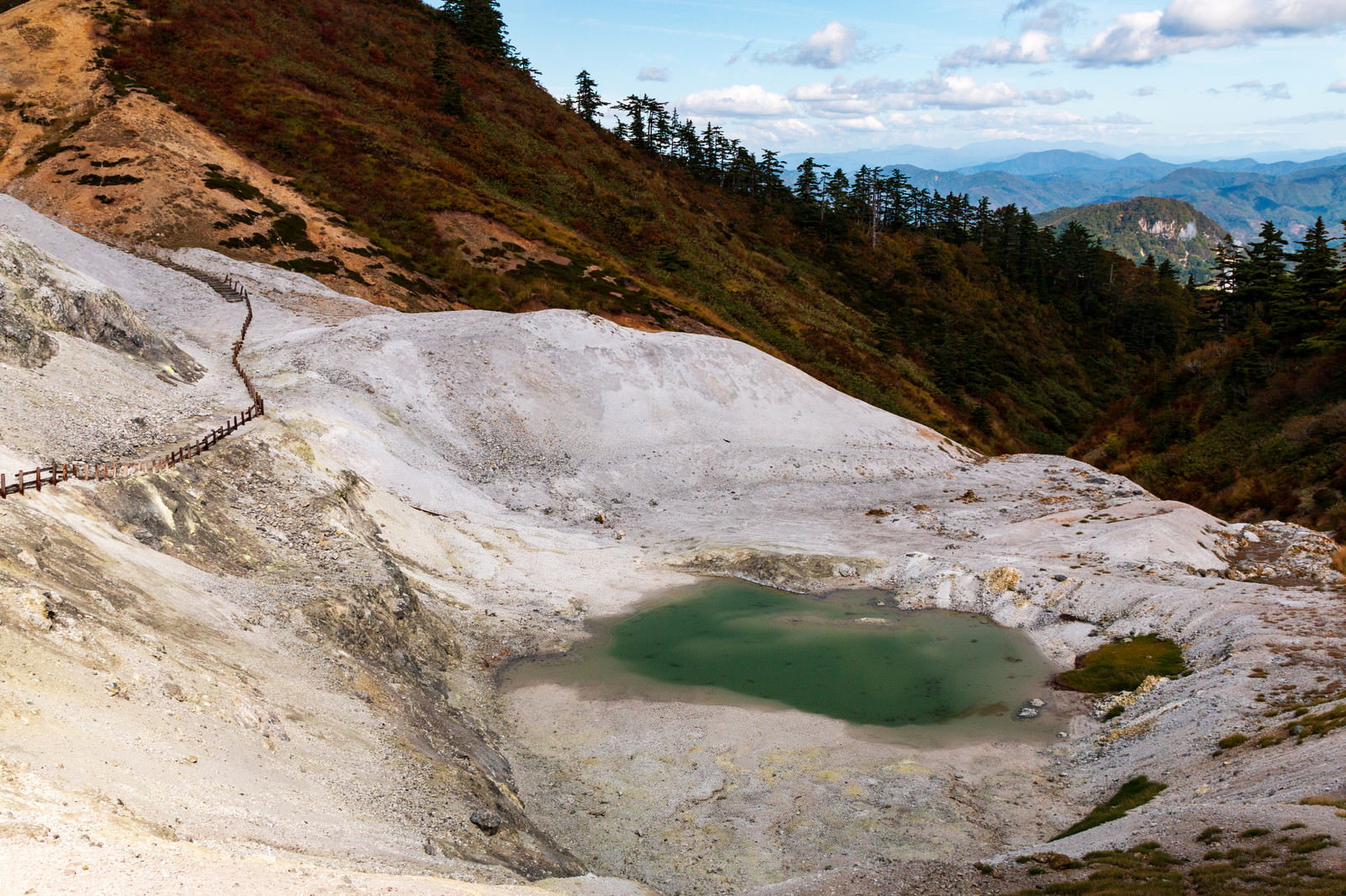 川原毛地獄の白い岩肌とエメラルドグリーンの池