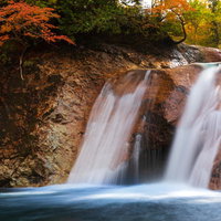 秋田県東成瀬村の紅葉と赤滝から落ちる水の流れの写真